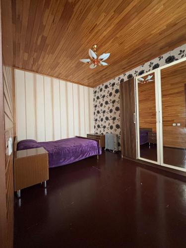 a bedroom with a purple bed and a ceiling fan at Mountain view in Gabala in Bunud