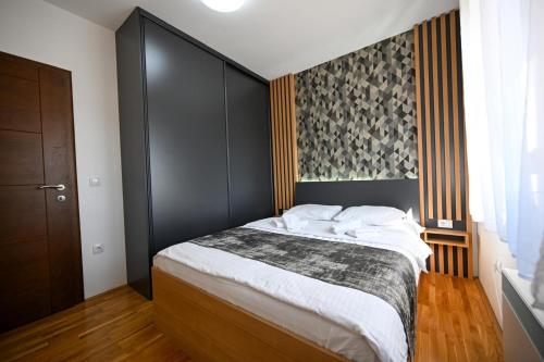 a bedroom with a large bed with a black headboard at Black Diamond Zlatibor in Zlatibor