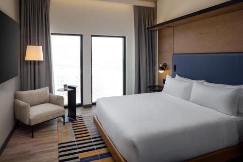 a bedroom with a large white bed and a chair at Canopy By Hilton Nashville Downtown The Gulch in Nashville