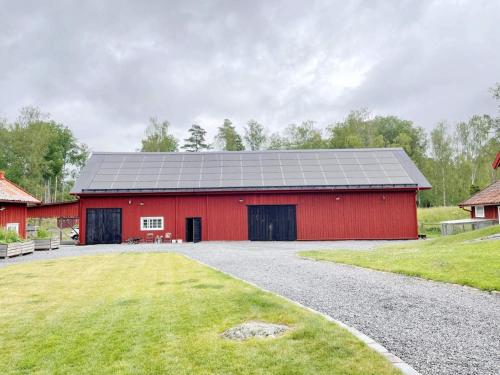 a red barn with a gray roof at 4 person holiday home in Mellösa in Mellösa