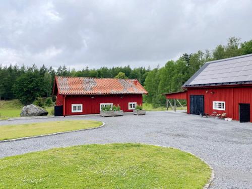 a red barn with two red buildings and a driveway at 4 star holiday home in Mellösa-By Traum in Mellösa