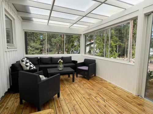 a screened in porch with a couch and chairs and windows at 4 star holiday home in Mönsterås-By Traum in Mönsterås