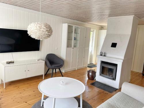 a living room with a table and a fireplace at 4 star holiday home in Mönsterås-By Traum in Mönsterås