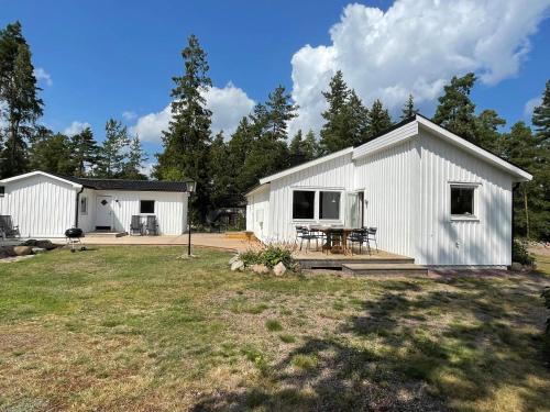 a white barn with a picnic table in a yard at 4 star holiday home in Mönsterås-By Traum in Mönsterås