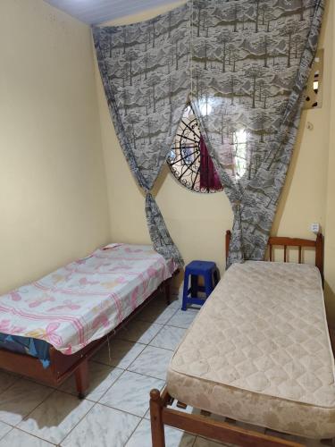a bedroom with two beds and a window at Casarão Mosqueiro Castle in Belém