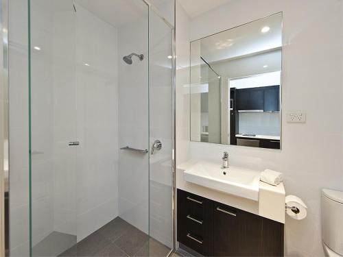 een badkamer met een wastafel en een glazen douche bij Quest Rockingham in Rockingham