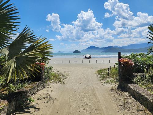 a dirt road leading down to a beach with the ocean at Chalés Villa do Mar in Ubatuba