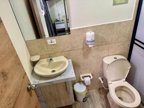 a small bathroom with a toilet and a sink at Best View Aparta Hotel in Dosquebradas