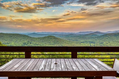 a wooden bench sitting on top of a view of mountains at Big Sky - Best Views in Blue Ridge in Epworth