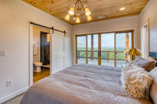 a bedroom with a large bed and a balcony at Big Sky - Best Views in Blue Ridge in Epworth
