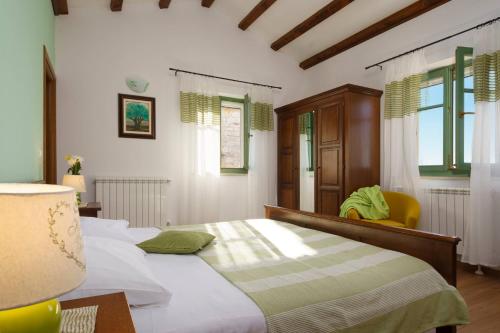 - une chambre avec un lit, une lampe et des fenêtres dans l'établissement Villa Baldasi, à Vižinada