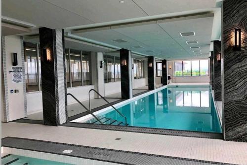 a swimming pool in a building with a large mirror at Shore Breeze in Toronto