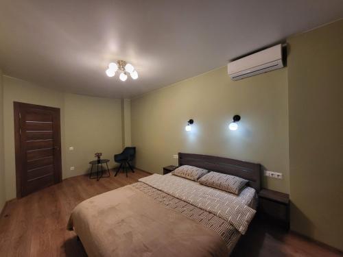 Un dormitorio con una cama grande y un ventilador de techo. en ЖК Bridge, en Rivne