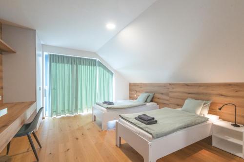 a bedroom with two beds and a desk and a window at Elements Chopok in Bystrá