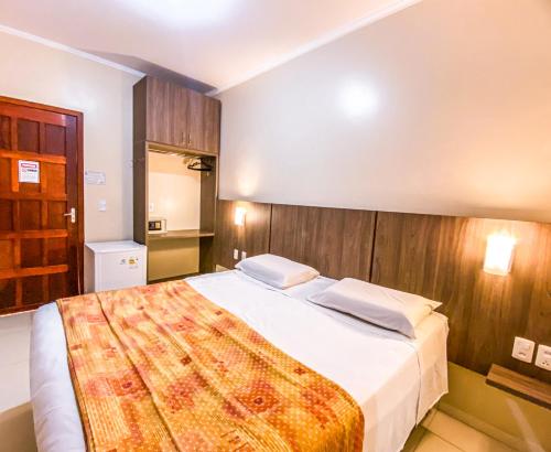 a bedroom with a large bed with a wooden wall at Pousada El Shaddai in Foz do Iguaçu