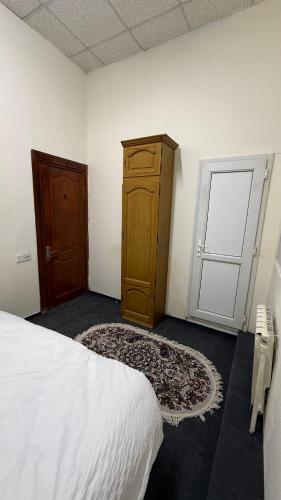 a bedroom with a bed and a wooden cabinet and a door at Lake View Hostel & Hotel baku in Baku