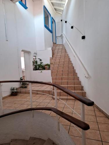 a staircase in a building with a metal railing at Casa Tortugas Manzanillo in Manzanillo