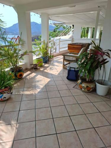 a patio with potted plants and a bench at Casa Tortugas Manzanillo in Manzanillo