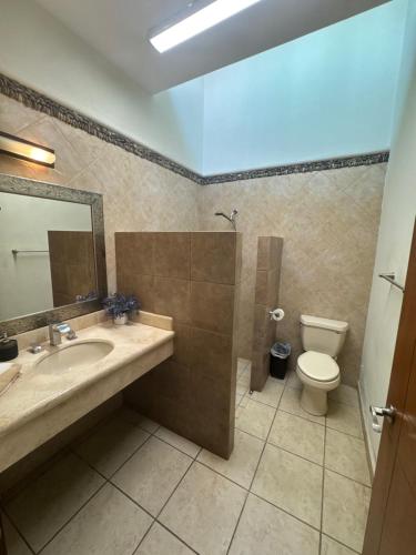 a bathroom with a sink and a toilet and a mirror at Casa de playa, a pasos del mar in Mazatlán