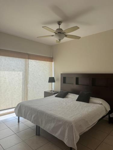 a bedroom with a bed and a ceiling fan at Casa de playa, a pasos del mar in Mazatlán