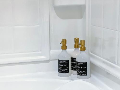 two bottles of soap sitting on top of a sink at Mid Century With Pool GYM and Parking 10min to Cedars in Los Angeles