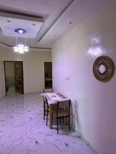 a room with a table and chairs and a clock on the wall at Immeuble Houleye Moctar Sow in Dakar