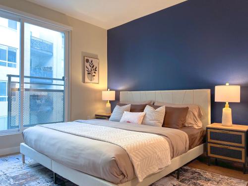 a bedroom with a large bed and a large window at Mid Century With Pool GYM and Parking 10min to Cedars in Los Angeles