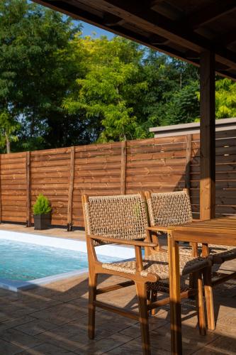 a wooden table and chairs sitting next to a pool at Kanva Suites in Korinós