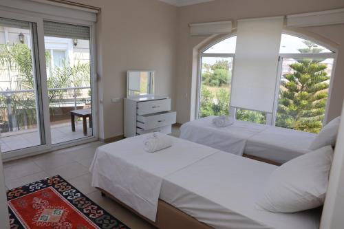 a bedroom with two beds and a balcony at Pine Golf Village Belek in Belek