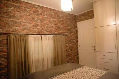 a bedroom with a brick wall and a shower at Pantelia LuxMax Experience in Loutraki