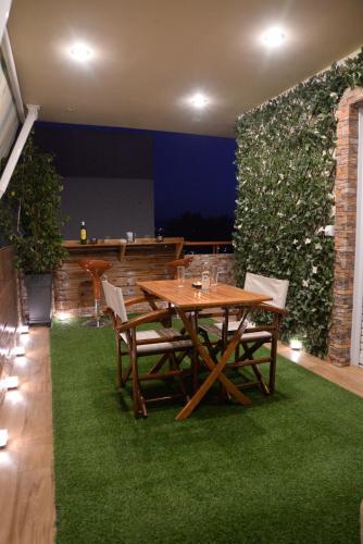 a dining room with a table and a green wall at Pantelia LuxMax Experience in Loutraki