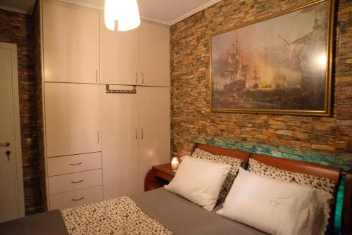 a bedroom with a bed and a brick wall at Pantelia LuxMax Experience in Loutraki
