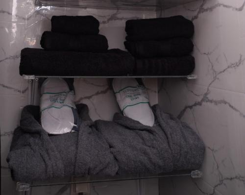 a towel shelf with towels and shoes on it at Pantelia LuxMax Experience in Loutraki