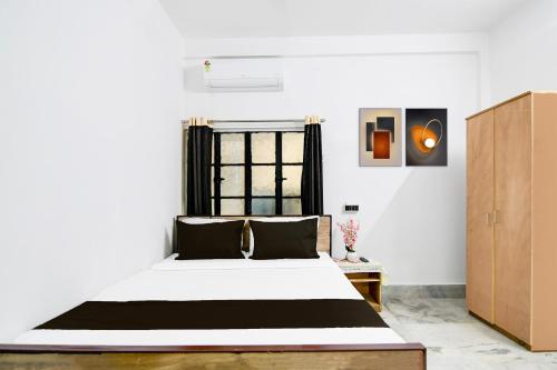 a bedroom with a bed and a window at Hotel O SAFAR STAY in Kolkata