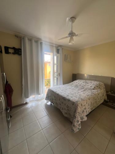 a bedroom with a bed and a large window at Casa Rocha in Porto Seguro