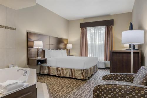 a hotel room with a large bed and a bathroom at Best Western Plus Bridgewater Hotel & Convention Centre in Bridgewater