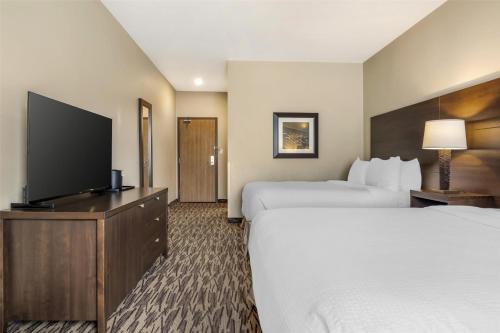 a hotel room with two beds and a flat screen tv at Best Western Plus Bridgewater Hotel & Convention Centre in Bridgewater