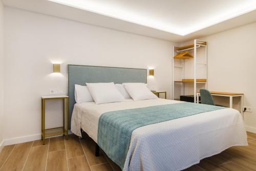 a bedroom with a large bed with a blue blanket at CH Las Artes de Atocha in Madrid