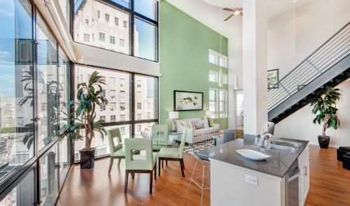 a kitchen and living room with large windows at Mid Century With Pool GYM and Parking 10min to Cedars in Los Angeles