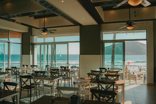 a dining room with tables and chairs and the ocean at Oceano Palace in Mazatlán