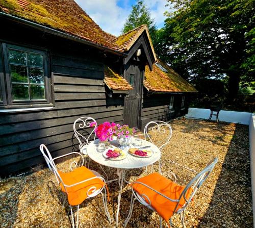 a table and chairs in front of a cabin at Bessie May Cottage in Beaulieu