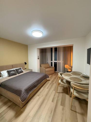 a bedroom with a large bed and a table at Apartment Polyana Green Park in Polyana
