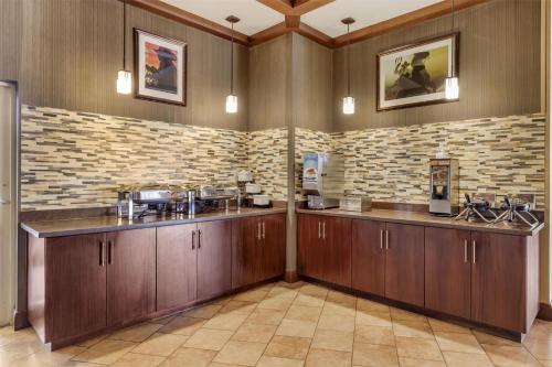 una cocina con armarios de madera y una pared de ladrillo en Best Western Plus Cedar City, en Cedar City