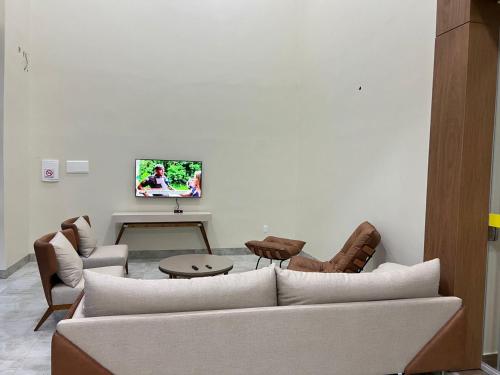 a living room with a couch and a tv on a wall at Hotel Porto Sollar in Porto Nacional