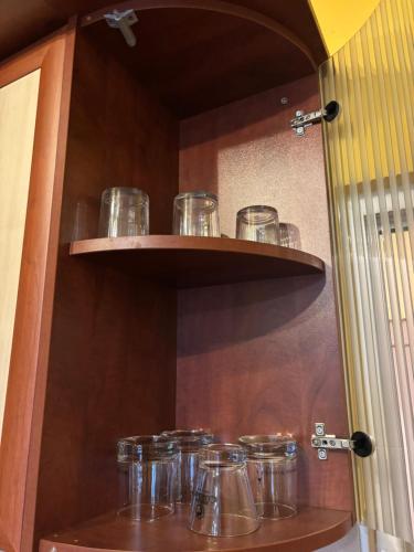 a row of glasses on shelves in a kitchen at Galina apartment in Ruse
