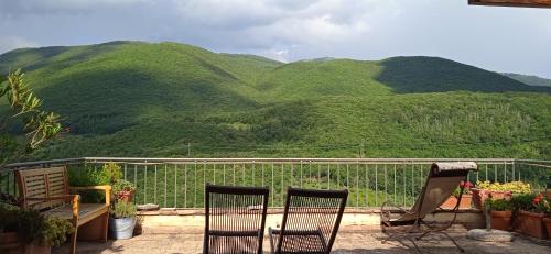 two chairs sitting on a balcony with mountains in the background at La Torretta Historical Home in Casperia