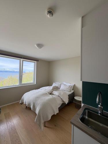 a bedroom with a bed with a sink and a window at Cozy Apartment in Tromsø