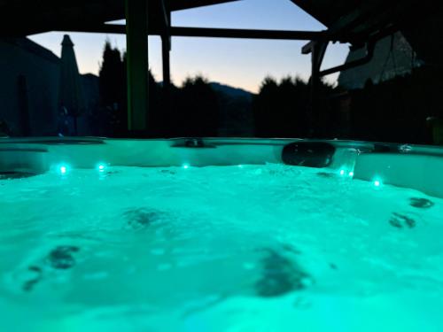 a jacuzzi tub with blue lights in the dark at Domček s tenisovým kurtom v srdci Liptova in Ivachnová