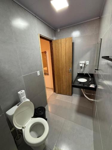 a bathroom with a toilet and a sink at Vila Orun Pousada in Barreirinhas
