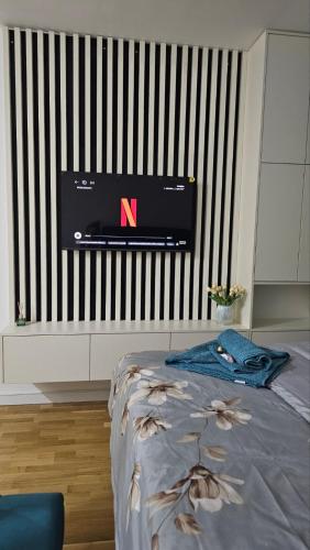 a bedroom with a bed with a tv on the wall at Harmonija Priboj in Priboj